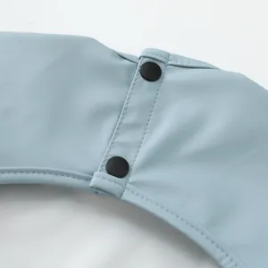 Primer plano detallado del babero impermeable para bebés mostrando costuras y botones.