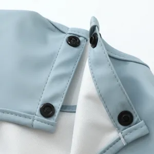 Detalle de babero impermeable para bebé, babero azul claro con botones de presión y costuras.