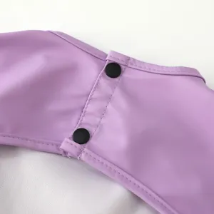 Closeup detail of purple waterproof baby bib, secure black snap buttons and neat stitching finish.