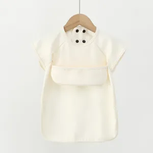 Close-up detail of cream white waterproof baby short sleeve PU bib with snap buttons.