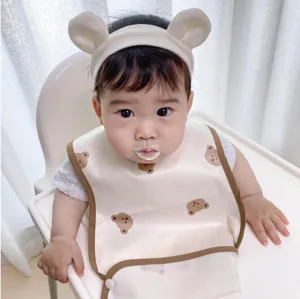 Waterproof baby feeding bib with cute bear pattern and soft material for daily use.