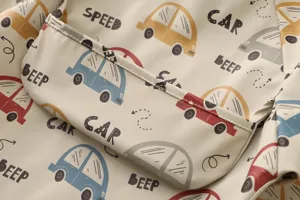 Close-up detail of waterproof baby feeding smock long sleeve cute car print pocket fabric