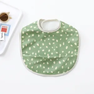 Waterproof baby bib with cute green and beige dot pattern, perfect for messy toddler feeding.