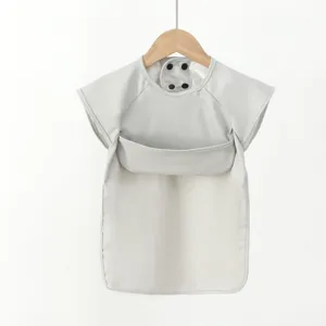 Close-up view of waterproof baby bib, short sleeve PU dining apron with large pocket.