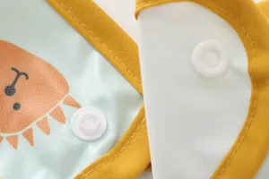 Close-up view of waterproof baby bib detail, showing yellow edge trim and snap button.
