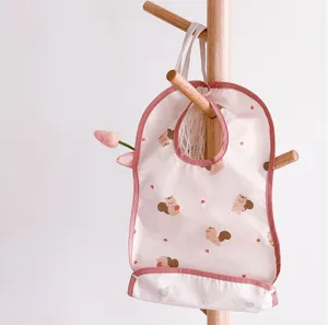 Waterproof baby bib with cute squirrel pattern and food catcher pocket for toddlers.