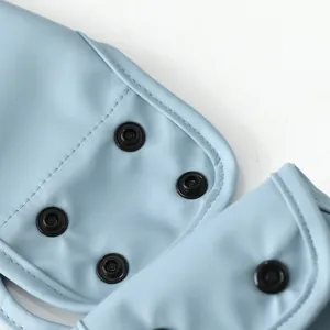 Close-up detail of light blue baby PU bib featuring black snap buttons and neat stitching.
