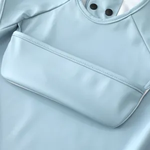 Waterproof baby bib with front pocket and snap buttons, soft PU material for toddler feeding.