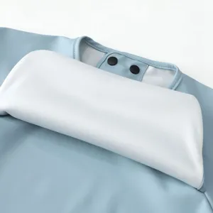Detail view of soft waterproof baby PU bib collar and snap button design, breathable smock.