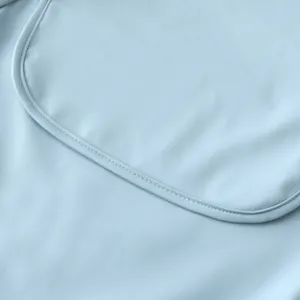 Λεπτομέρεια αδιάβροχης σαλιάρας PU σε γαλάζιο, λεπτές ραφές και λεία υφή υφάσματος.