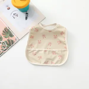 Waterproof baby bib detail featuring cute cartoon bear pattern and convenient crumb catcher pocket.