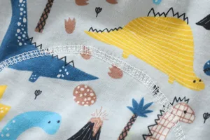 Gros plan sur le tissu de culotte d'apprentissage en coton pour bébé avec motif de dinosaure.
