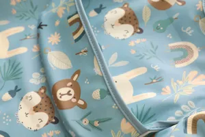 Detailansicht des wasserdichten Langarm-Babylatzes mit süßem Bären- und Hasenmuster in hellem Blau.