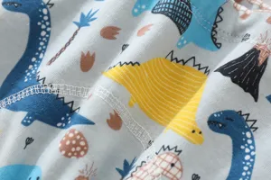 Gros plan sur le tissu de culotte d'apprentissage bébé en coton imprimé dinosaure mignon.
