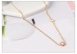 Gold stainless steel chain necklace featuring a cubic zirconia and a cute pink enamel daisy flower pendant.
