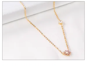 Stainless steel gold necklace with sparkling crystal and cute pink daisy pendant detail.