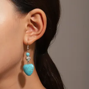 Detaillierte Nahaufnahme eines Vintage-Ohrrings mit Türkisherz an einem Modellohr.