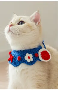 Handmade crochet blue pet collar with cute floral and pom-pom decorations for cats.