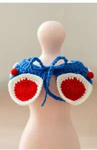 Detail view of handmade crochet pet bib, cute blue and red knitted collar for cats and dogs.