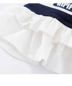 Süßes Haustierkleid Detailaufnahme mit gestuften weißen Rüschen und marineblauem Stoff.
