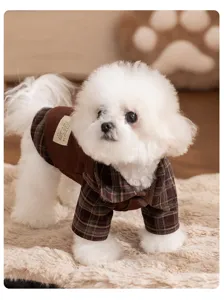 Detailed view of a cute puppy wearing a cozy brown plaid pet shirt, warm winter dog clothes.
