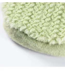 Primo piano dettagliato del morbido tessuto in pile verde chiaro per indumenti invernali.