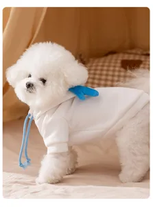 Close-up detail of cute white dog hoodie with blue wings and drawstring for small pets.
