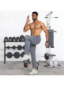 Detailed view of men grey sport pants in gym scene, breathable fitness activewear style.