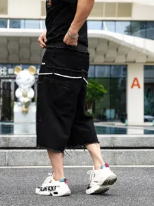 Pantaloncini di jeans neri da uomo con orlo vivo e patchwork in stile hip-hop casual.
