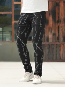 Detailed view of mens black slim fit stretch jeans featuring unique white embroidered patterns.