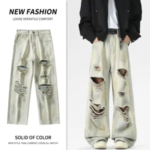 Vaqueros anchos vintage rotos para hombre con efecto lavado y estilo urbano moderno.