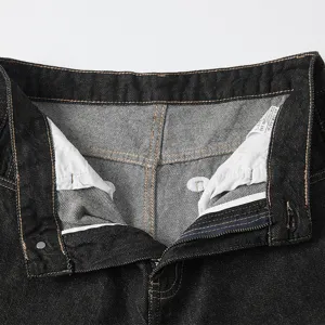 Men's dark loose straight denim jeans close-up view showing fly and inner care label