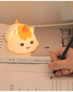 Close-up of a glowing cartoon unicorn silicone night light on a cozy magazine page.