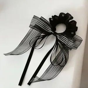 Gedetailleerd overzicht van een elegante zwarte haarscrunchie met lange doorzichtige linten.
