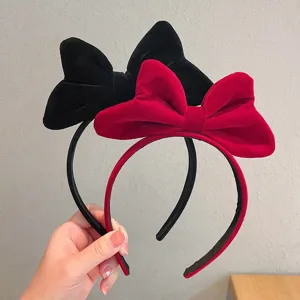 Velvet bow headband detail shot showing the soft texture and vibrant red and black colors.