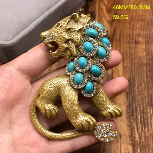 Vintage style gold lion brooch with turquoise and crystal rhinestones, detailed animal pin.