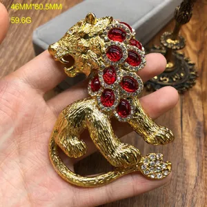 Vintage gold lion brooch featuring red gemstone and sparkling rhinestones for elegant women.