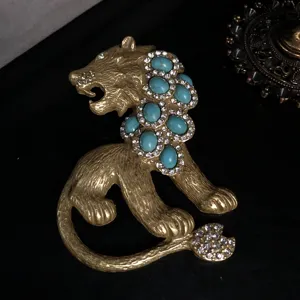 Vintage retro gold lion brooch inlaid with turquoise oval stones and dazzling clear rhinestones.