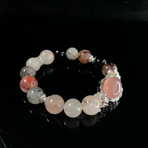 Natural crystal beaded bracelet with silver metal accessories and elegant pendant design.