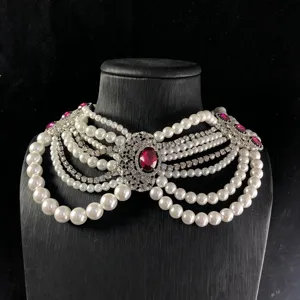 Vista detallada de collar gargantilla multicapa de perlas y estrás con gema rosa vintage.