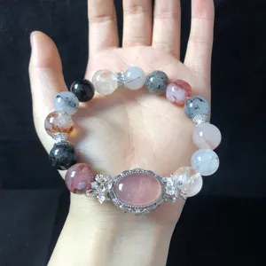 Multi-color crystal gemstone bracelet with luxury metal accessories and pink stone center charm.