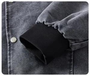 Giacca da baseball casual da uomo in primo piano, tessuto grigio scuro con polsini neri.