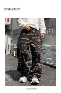 Vue détail du pantalon homme streetwear noir ample style décontracté avec impression graffiti.
