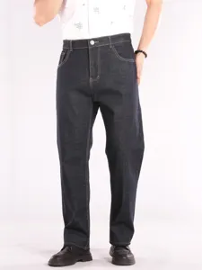 Close-up view of men's dark stretch denim jeans with high waist and clean stitching.