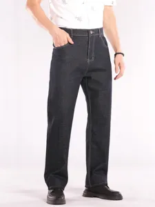 Close-up view of men's dark blue loose straight denim jeans showing fit, pockets and contrast stitching.