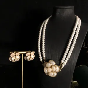 Vista detallada del conjunto de joyas de collar de perlas de doble capa y pendientes.