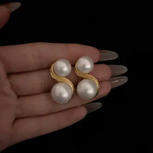 Pendientes de doble perla con cadena dorada retorcida estilo retro, vista detalle.