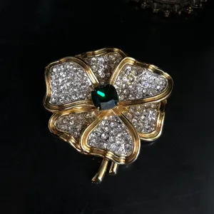 Broche fleur cristal vintage avec pierre verte centrale, élégante épingle mode dorée.
