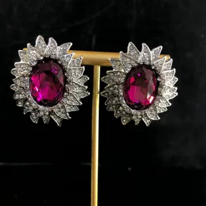 Vista detallada de pendientes vintage de diamantes de imitación con gran piedra morada.
