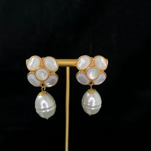 Close-up detail of elegant mother-of-pearl camellia flower earrings with baroque pearls.